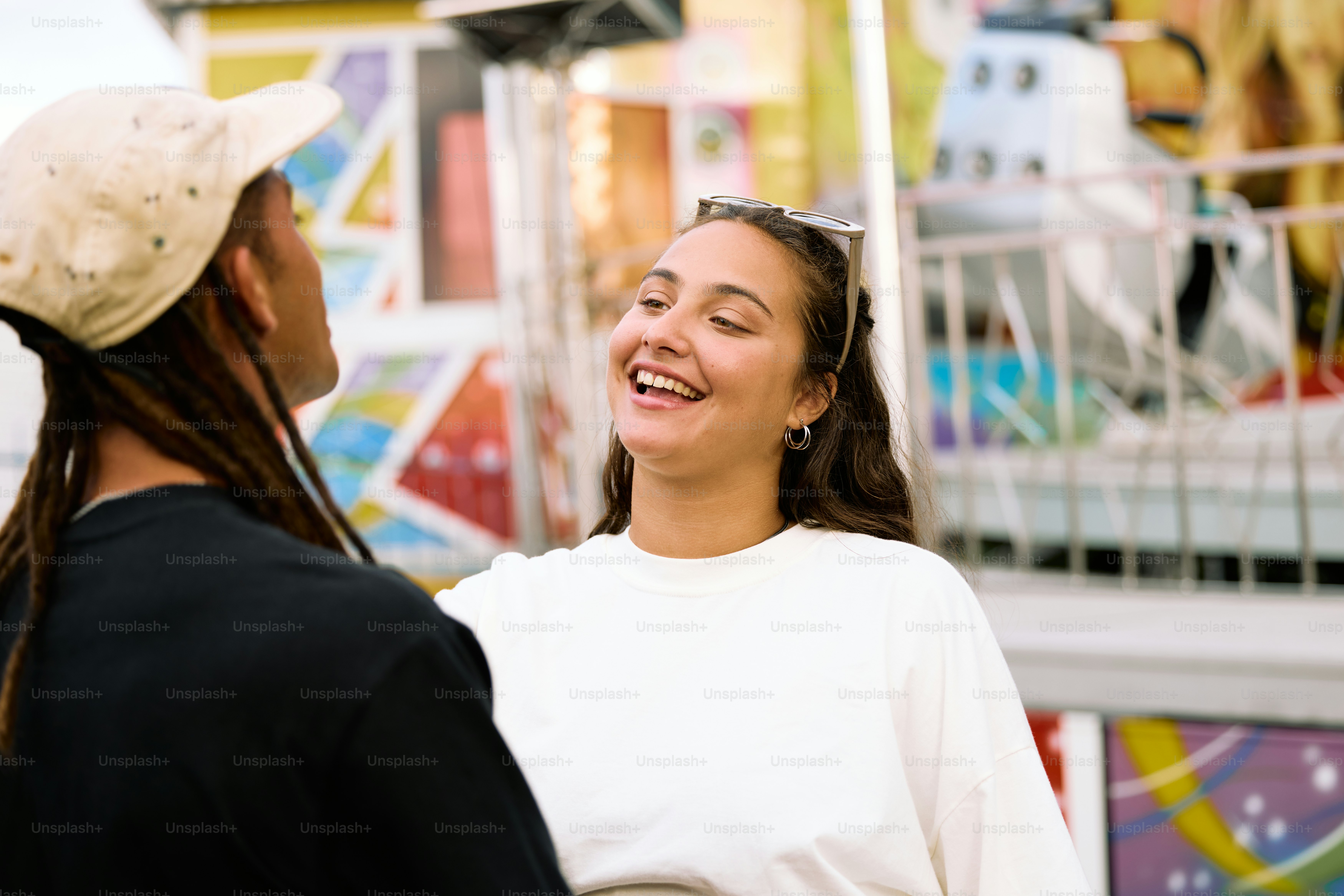 a woman standing next to another woman in front of a carnival ride