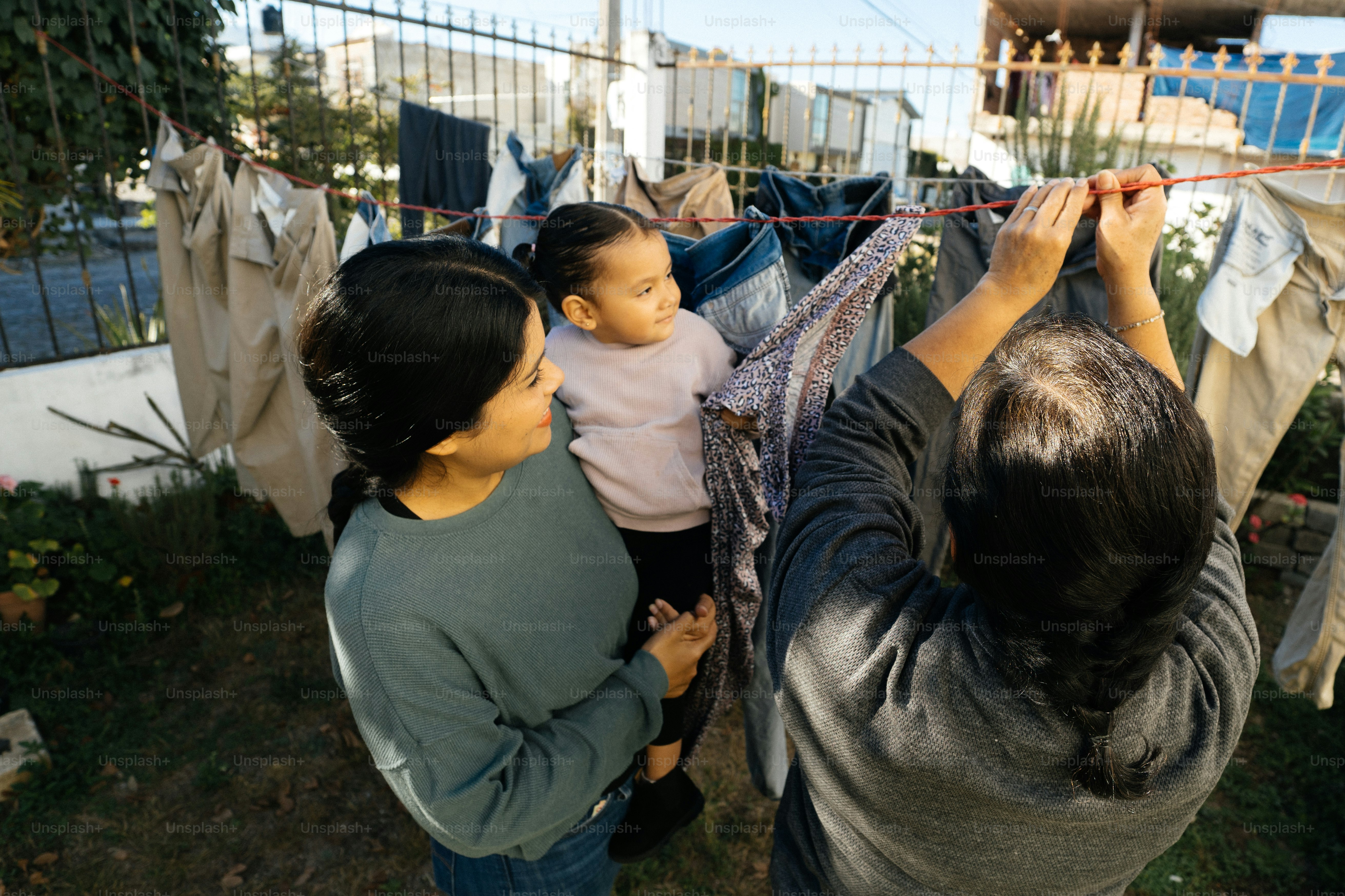 a woman holding a baby on a clothes line