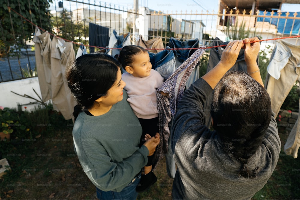 a woman holding a baby on a clothes line