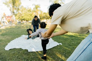 a group of people standing around a white blanket