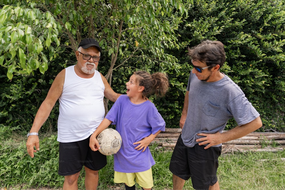 a man and two children holding a soccer ball