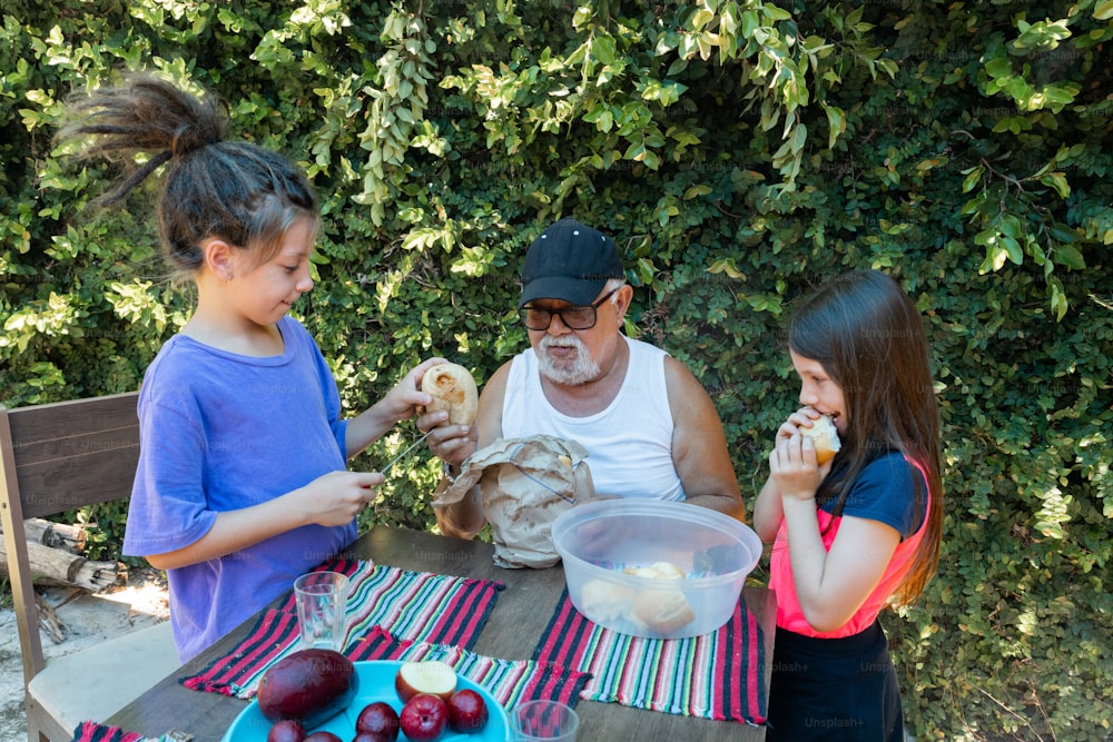 an older man and two young girls eating food