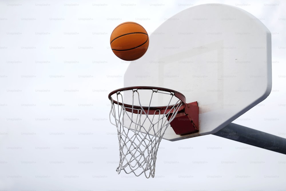 a basketball going through the hoop of a basketball hoop