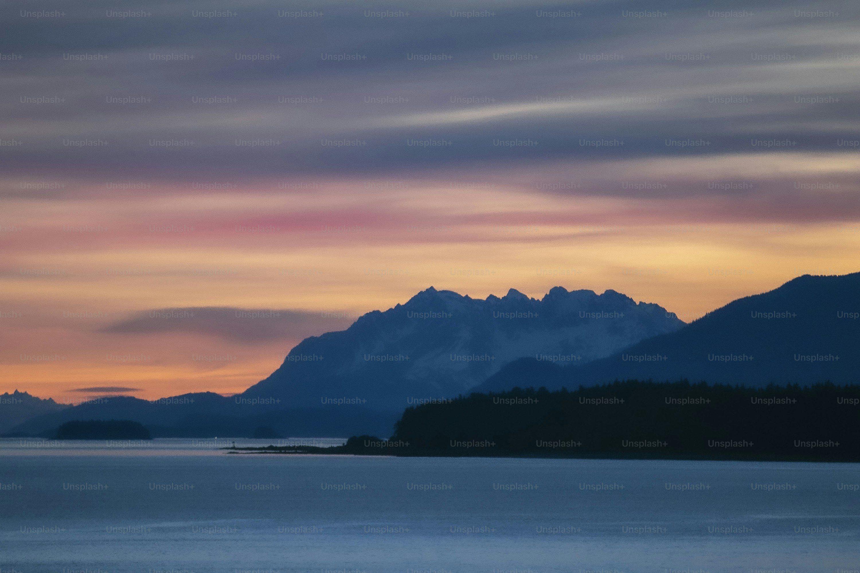 a mountain range with a body of water in the foreground