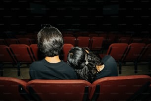 un couple de personnes assises dans un théâtre
