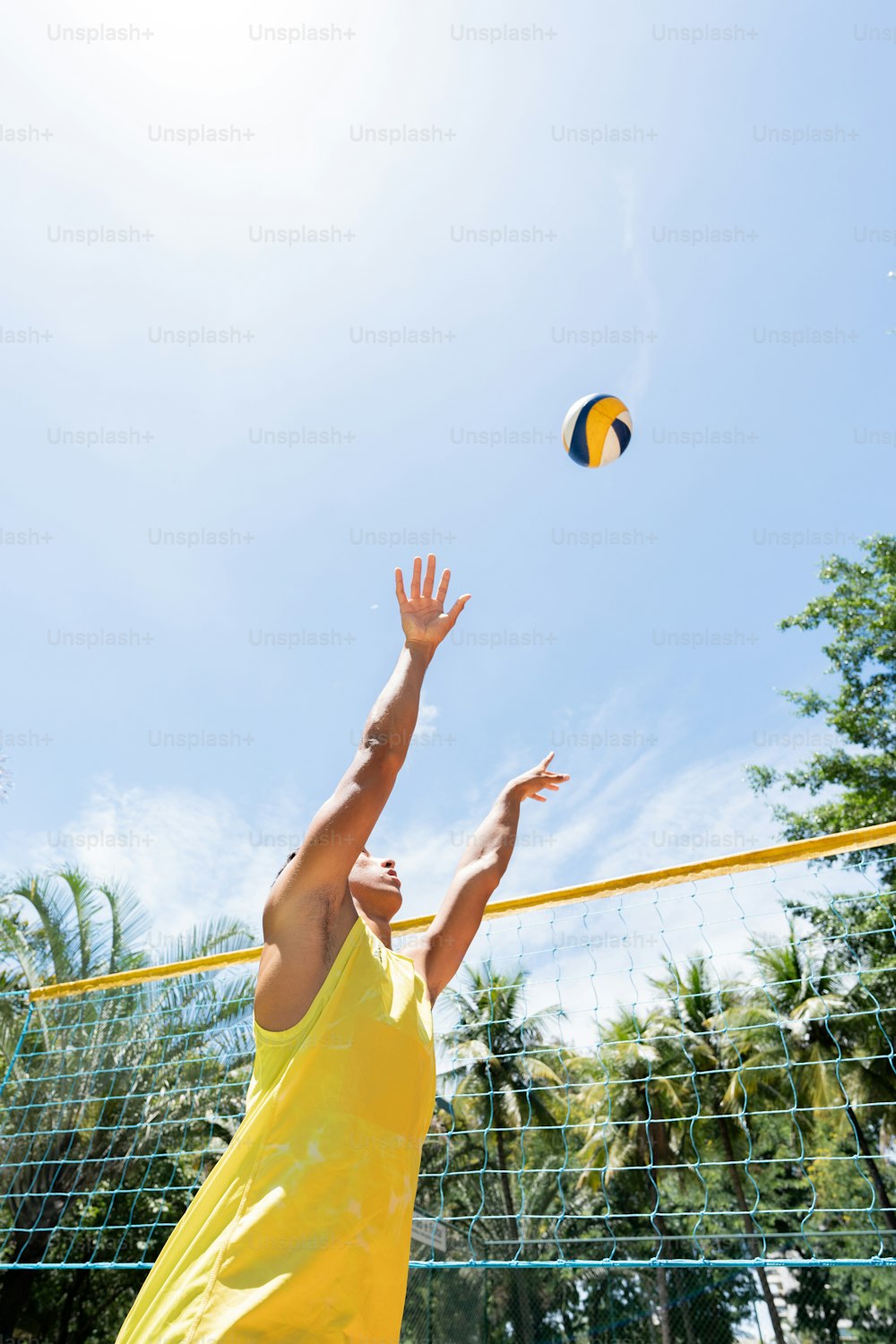 a man reaching up to hit a volley ball