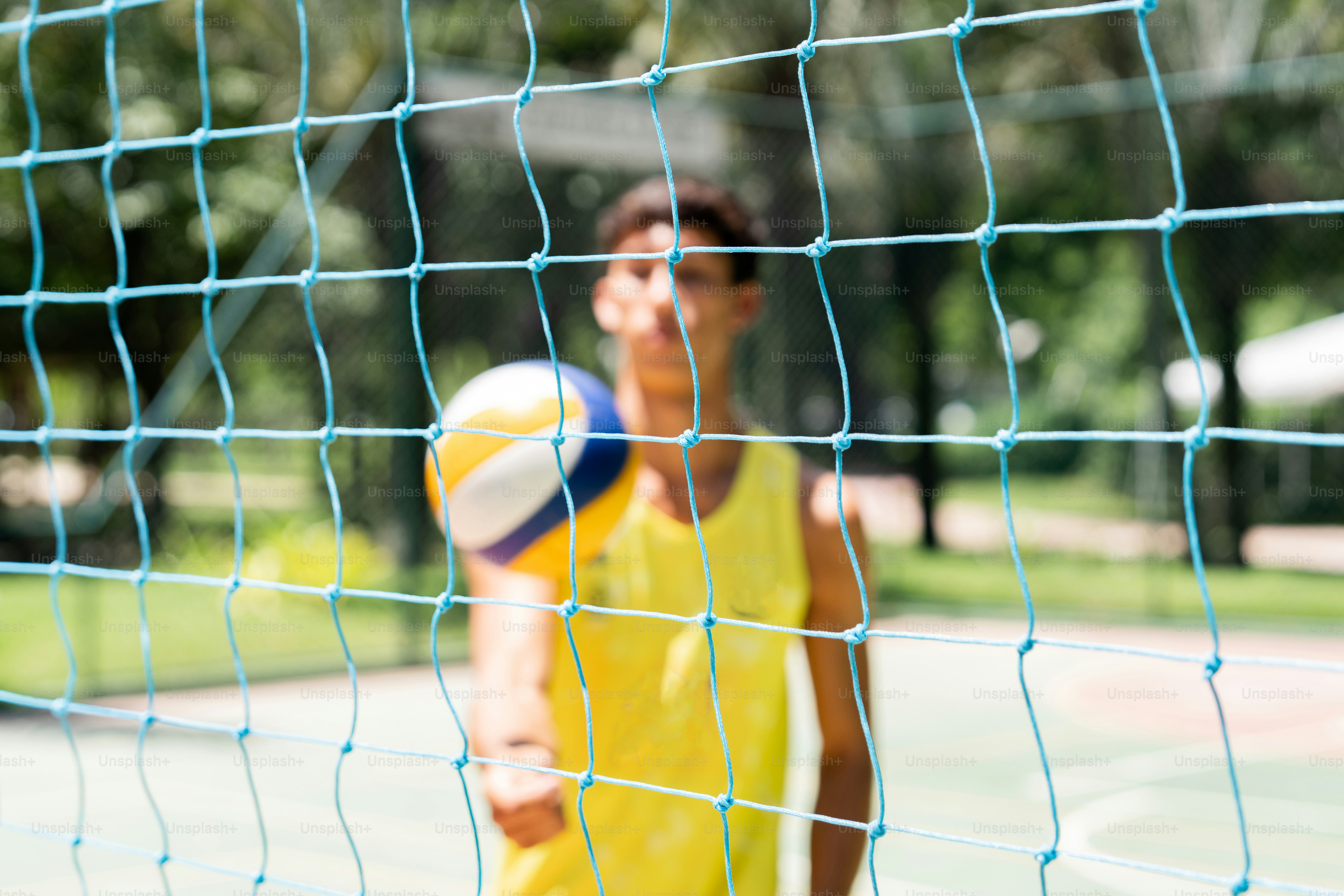 Un homme vêtu d’une chemise jaune joue au volley-ball