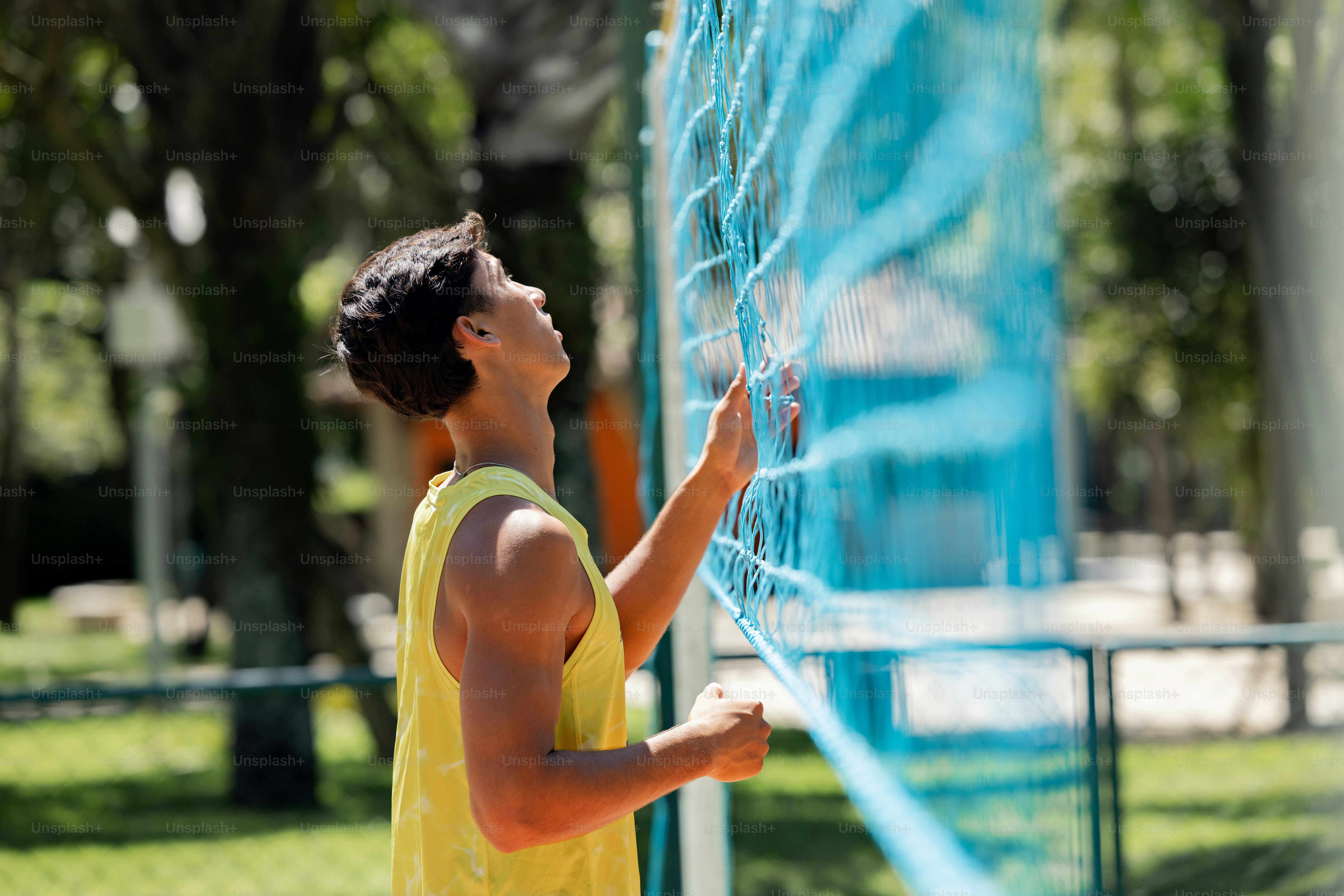 un giovane che tiene una racchetta da tennis in cima a un campo da tennis