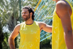a man in a yellow shirt standing next to a net