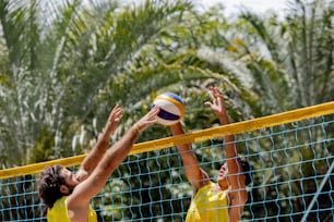 a couple of men playing a game of volleyball