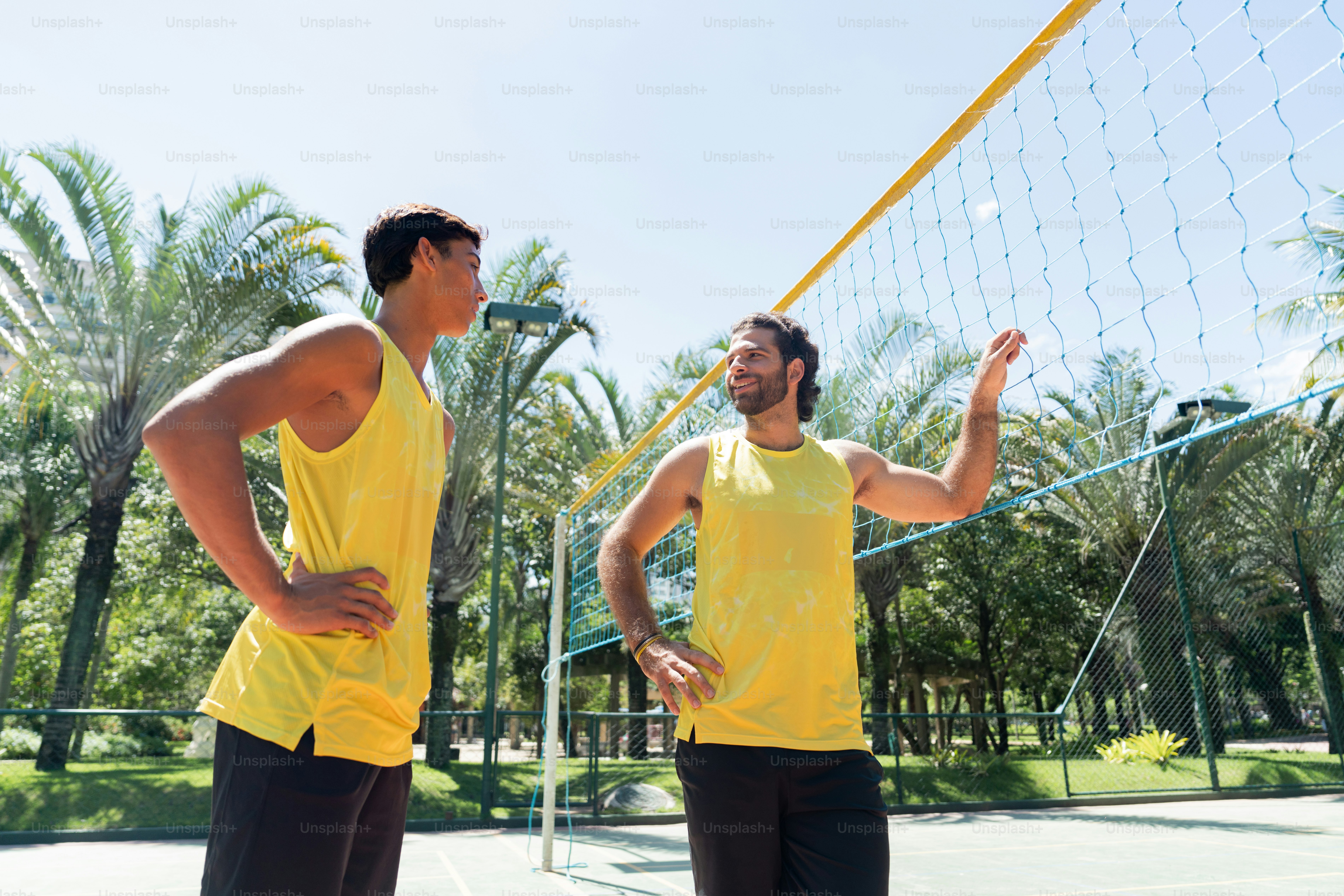 Un par de hombres parados encima de una cancha de tenis