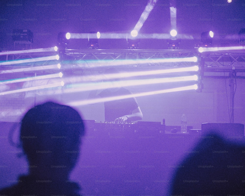 una persona parada frente a un escenario con luces