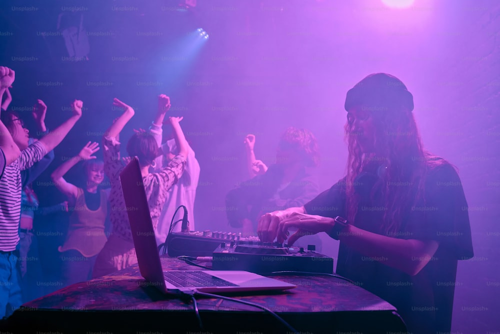 a group of people standing around a dj booth