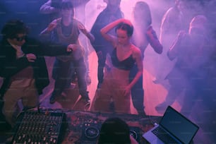 a group of people standing around a dj booth