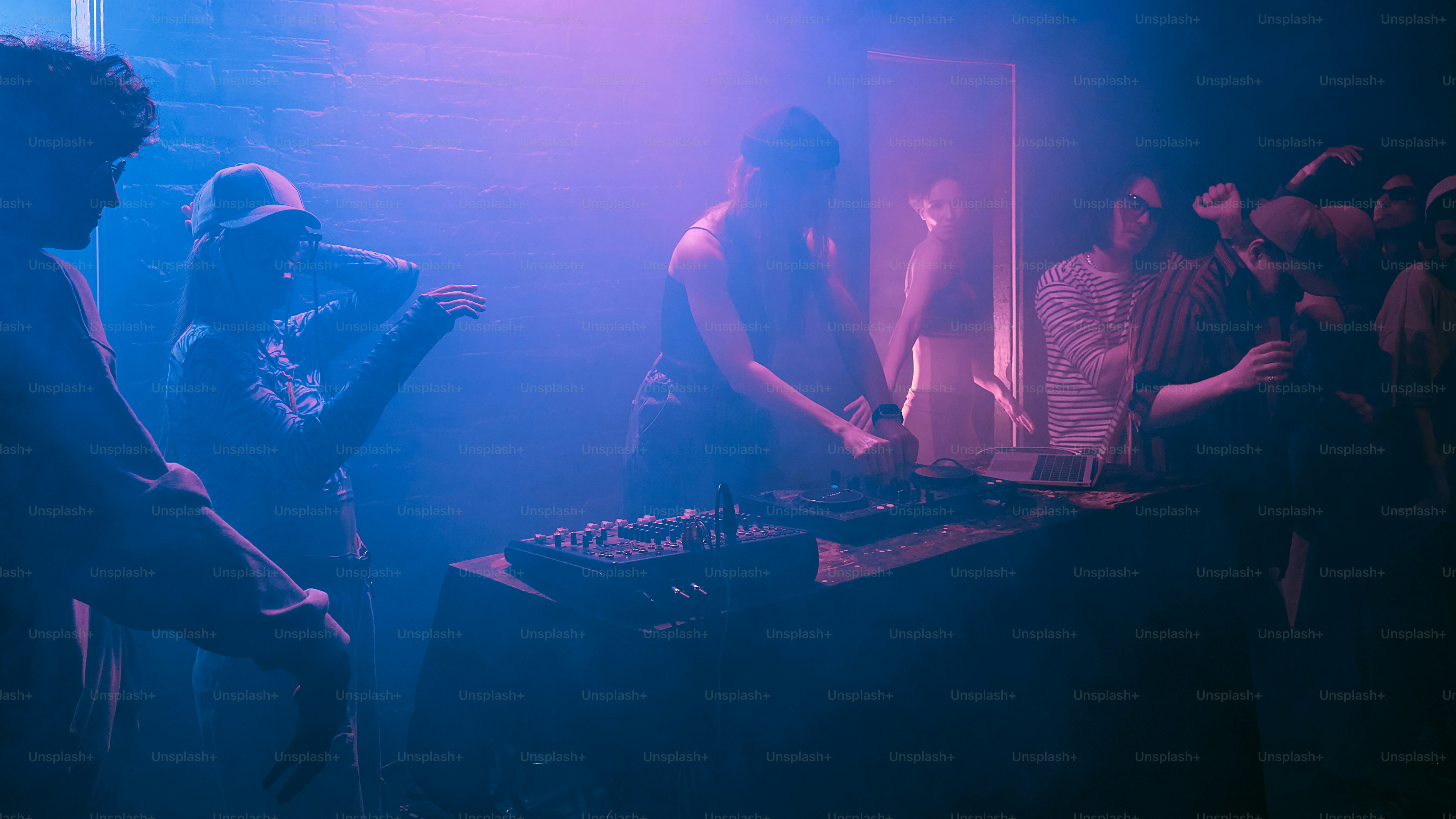 a group of people standing around a dj booth