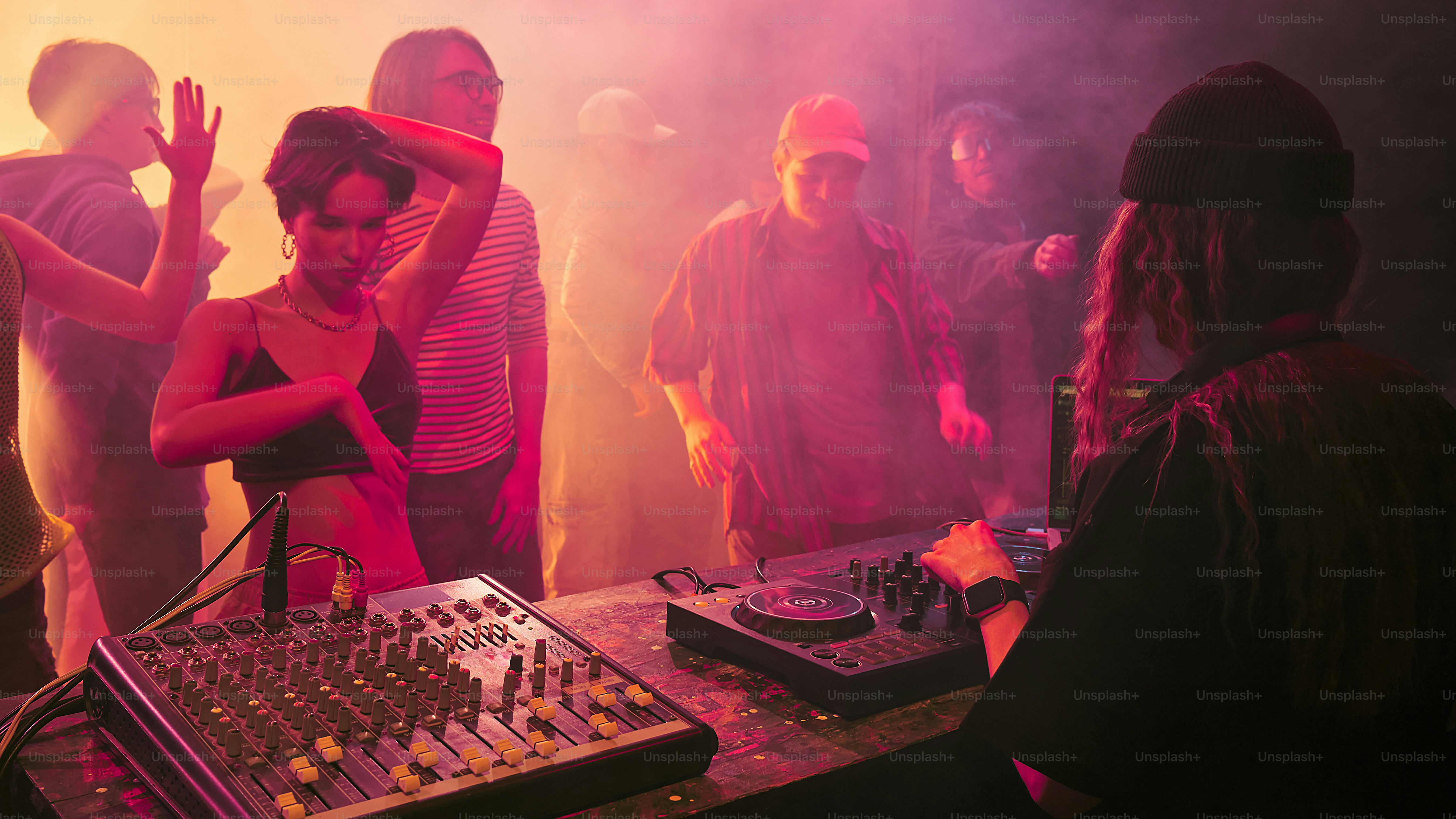 a group of people standing around a dj booth
