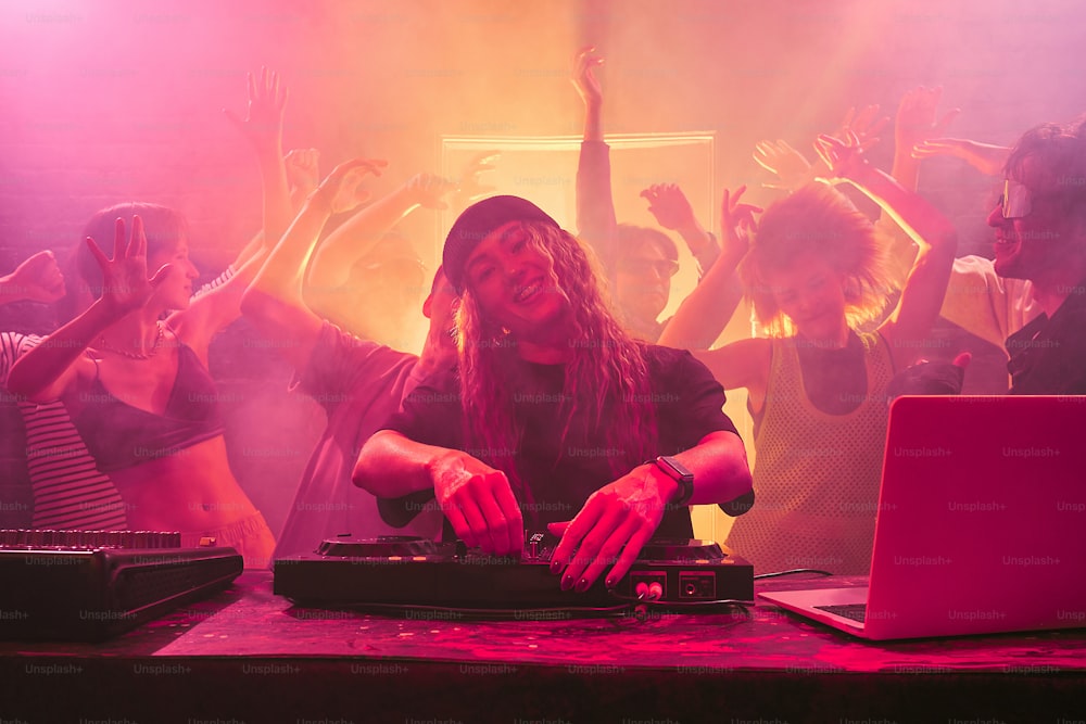 Um DJ misturando música na frente de uma multidão de pessoas
