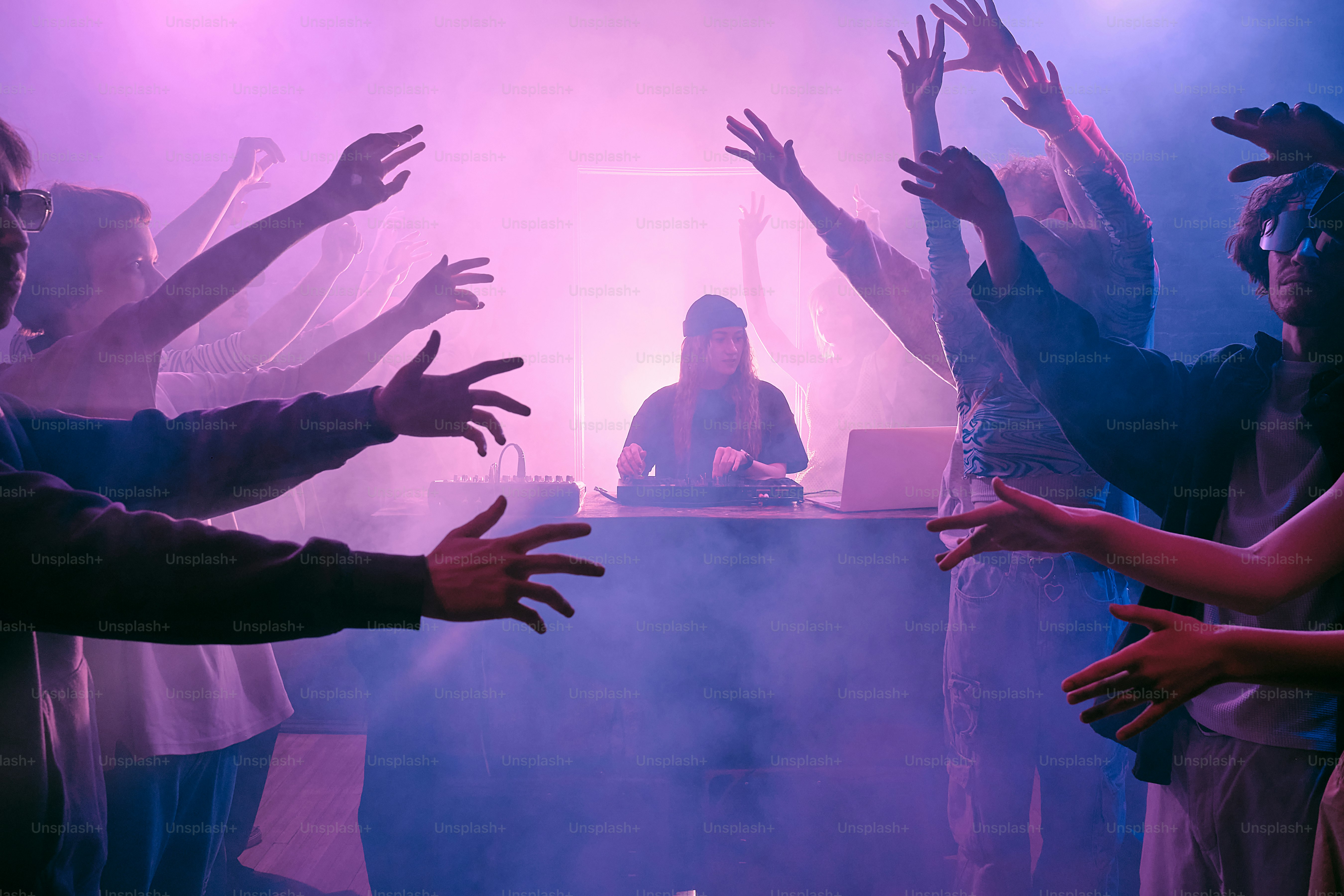 テーブルを囲んで両手を宙に浮かせて立っている人々のグループ