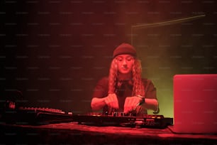 검은 모자를 쓴 여자가 DJ 세트를 연주하고 있습니다.