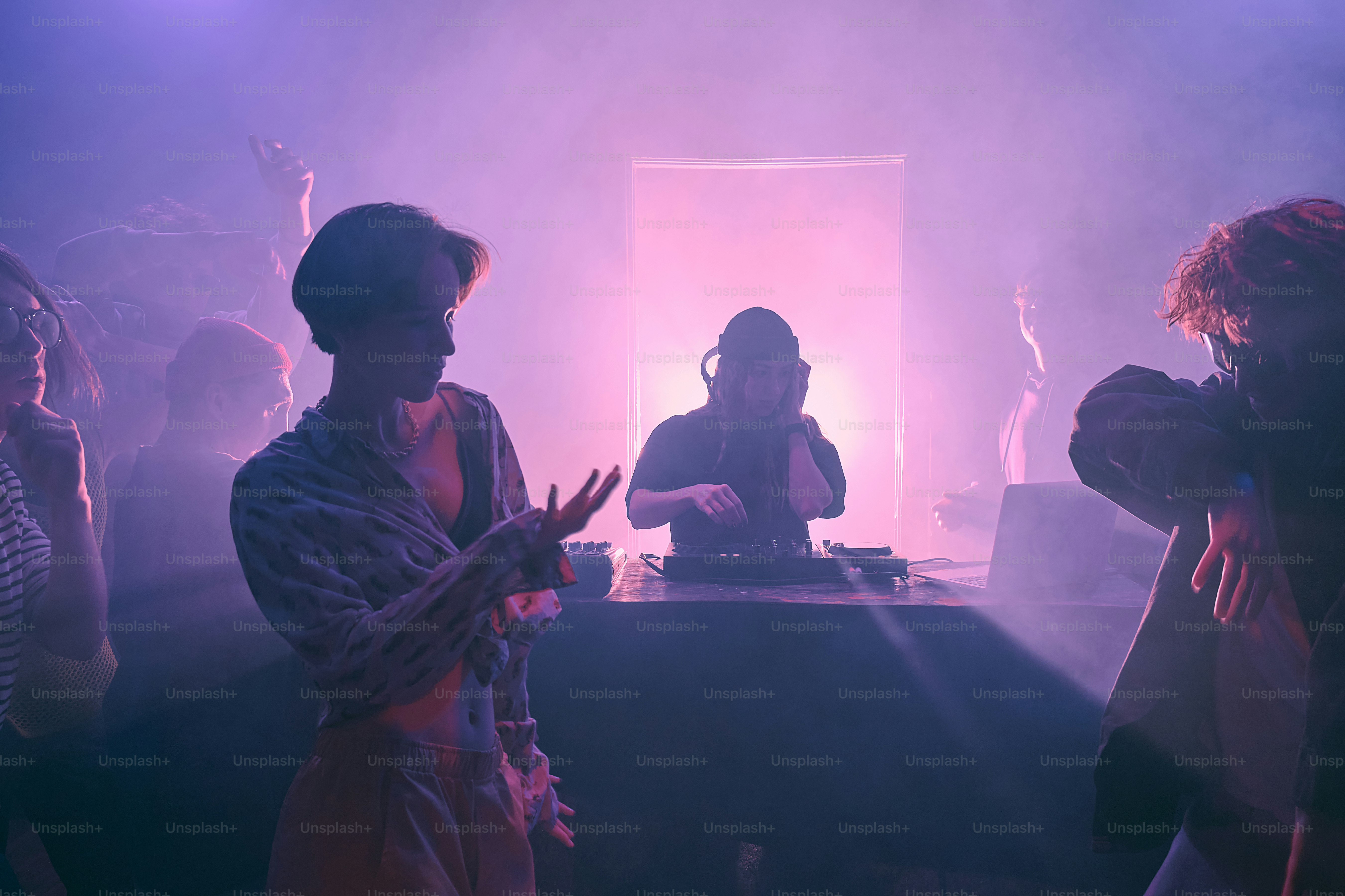 Un groupe de personnes debout autour d’une cabine de DJ