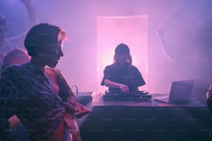 a woman djing in front of a crowd of people