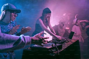 a group of people standing around a dj booth