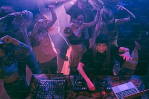Un gruppo di persone in piedi intorno a una cabina del DJ