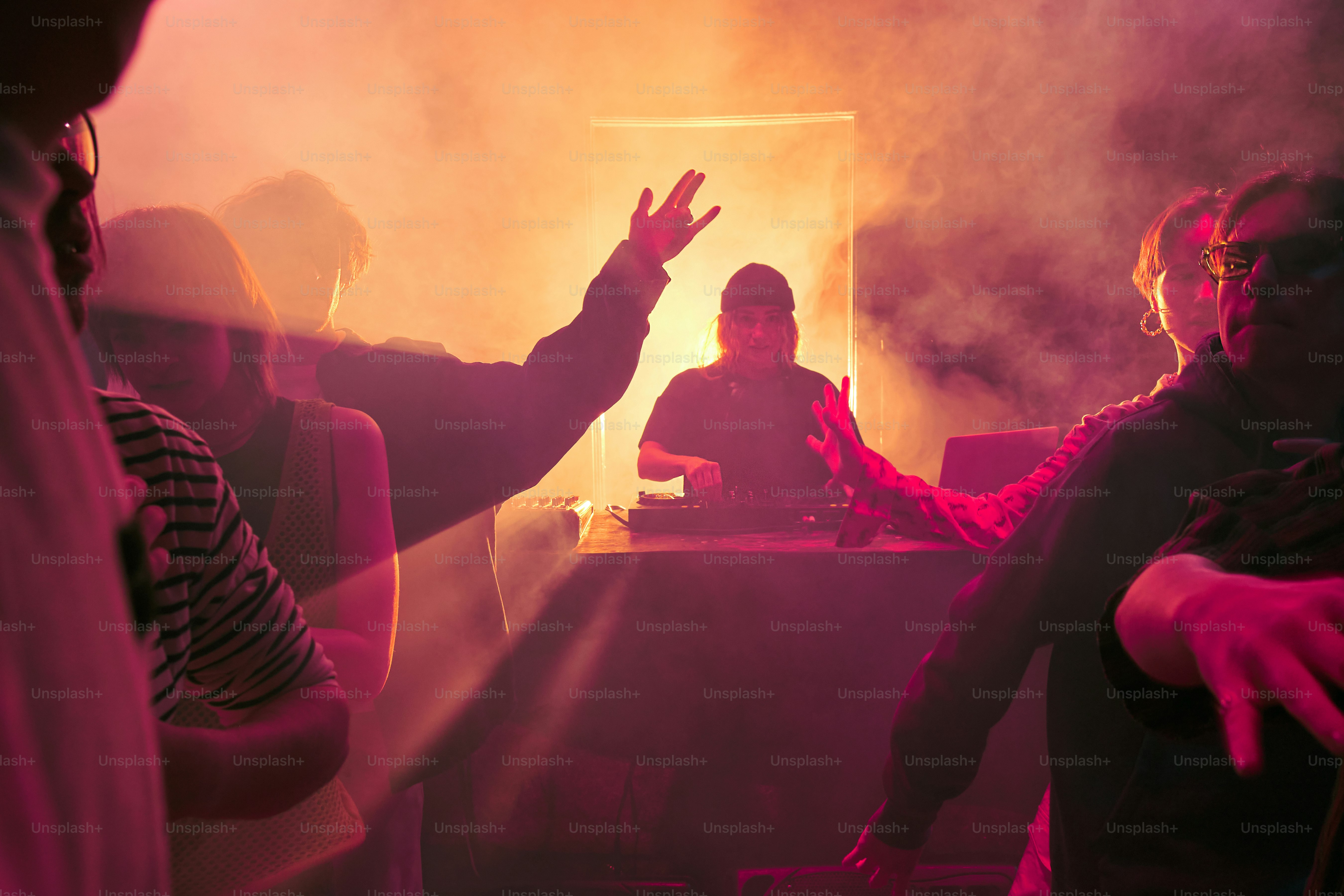 a group of people standing around a dj booth
