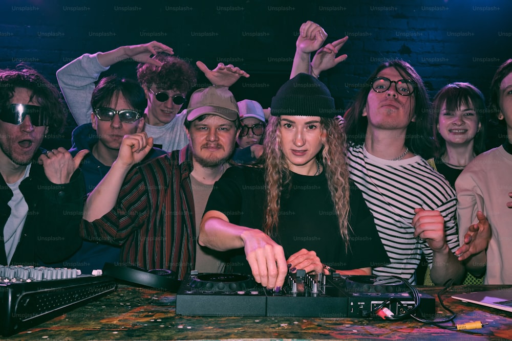 a group of people standing around a dj mixing