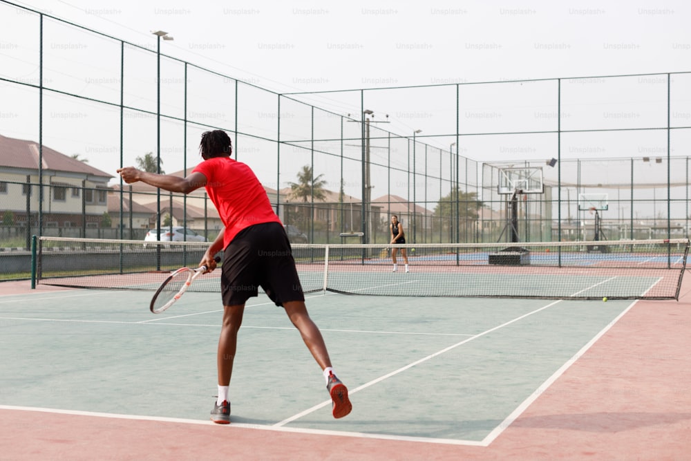 a man in a red shirt is playing tennis