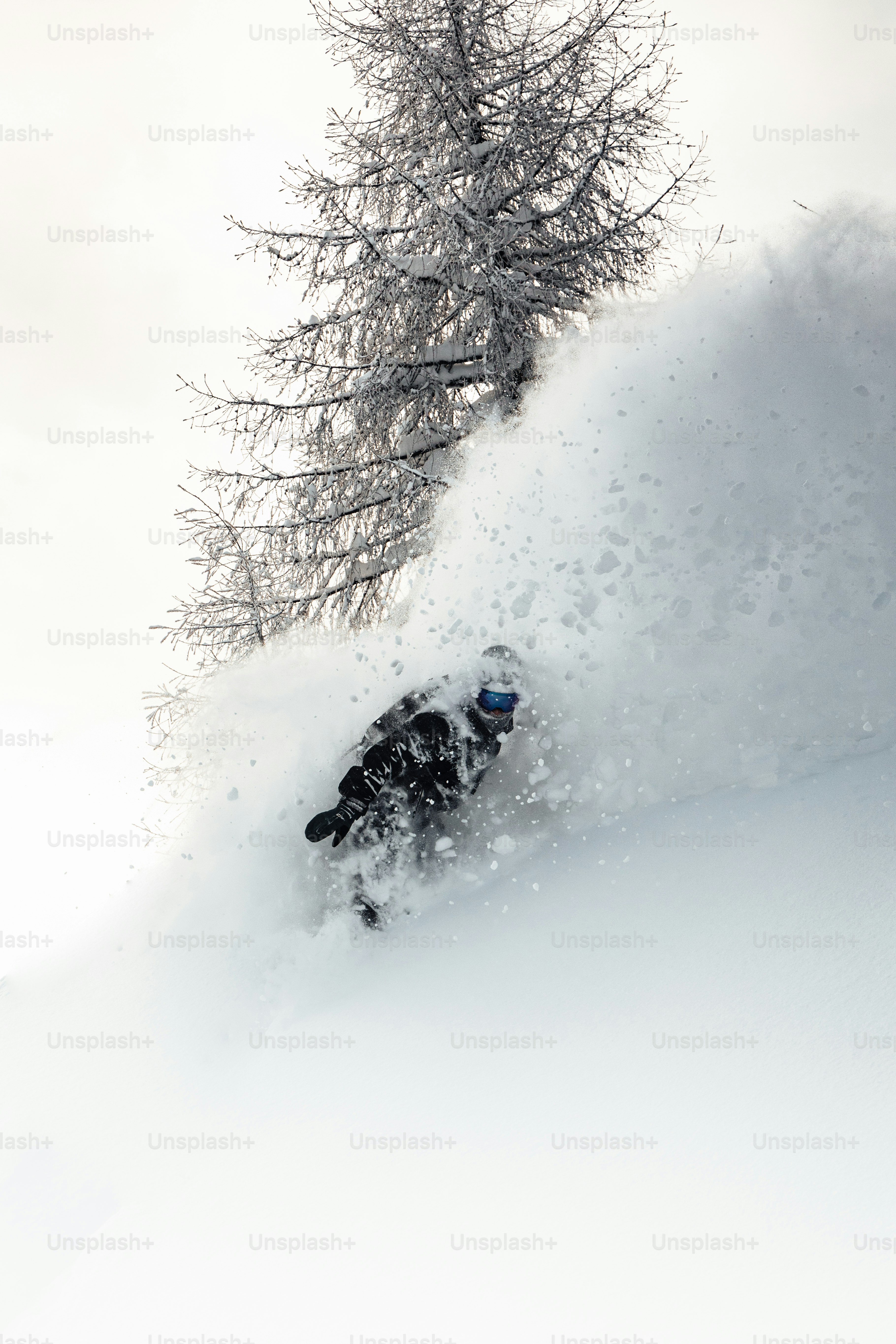 a man riding a snowboard down a snow covered slope