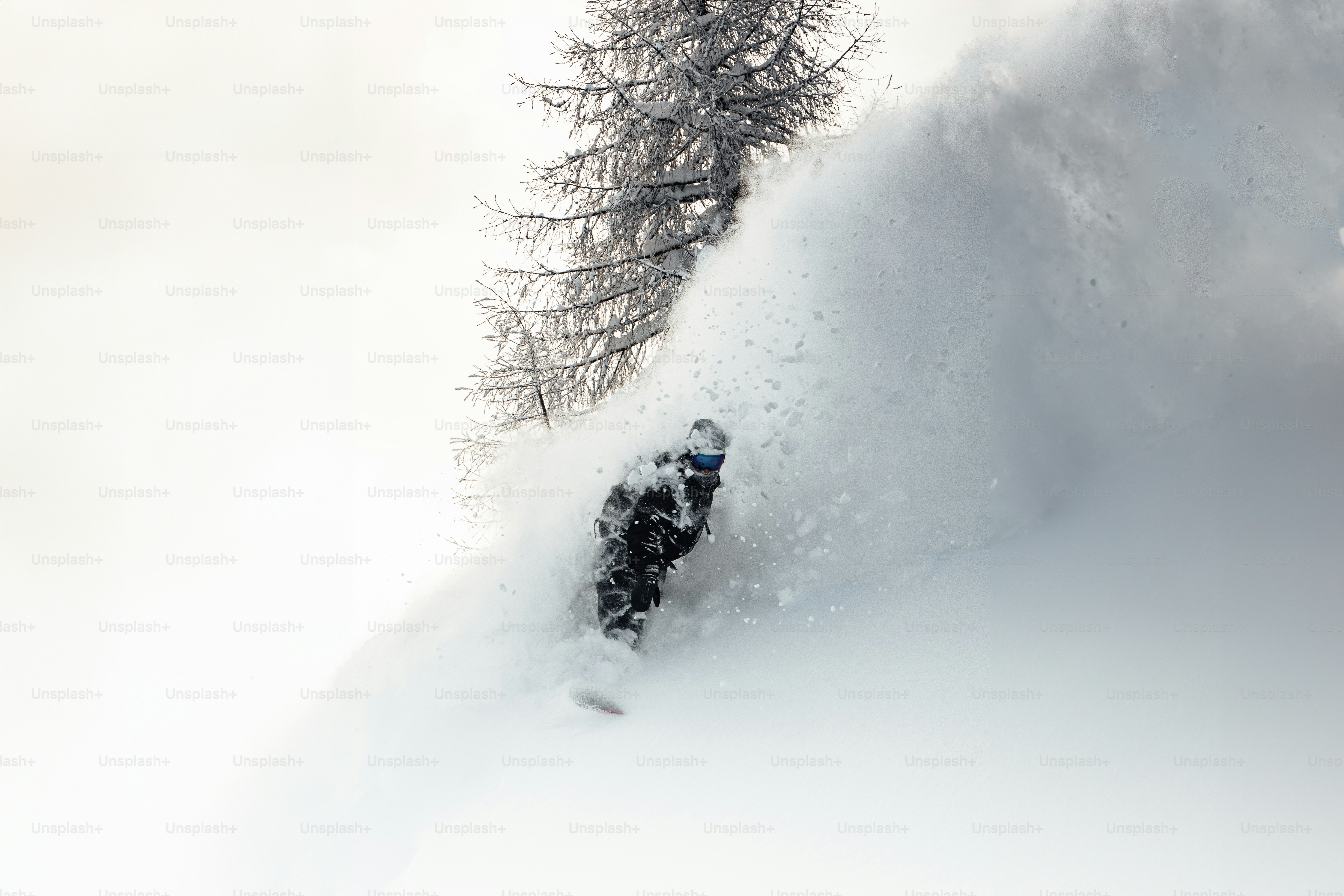 a man riding a snowboard down a snow covered slope