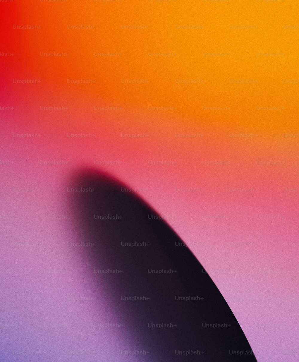 a blurry image of a black object on a colorful background