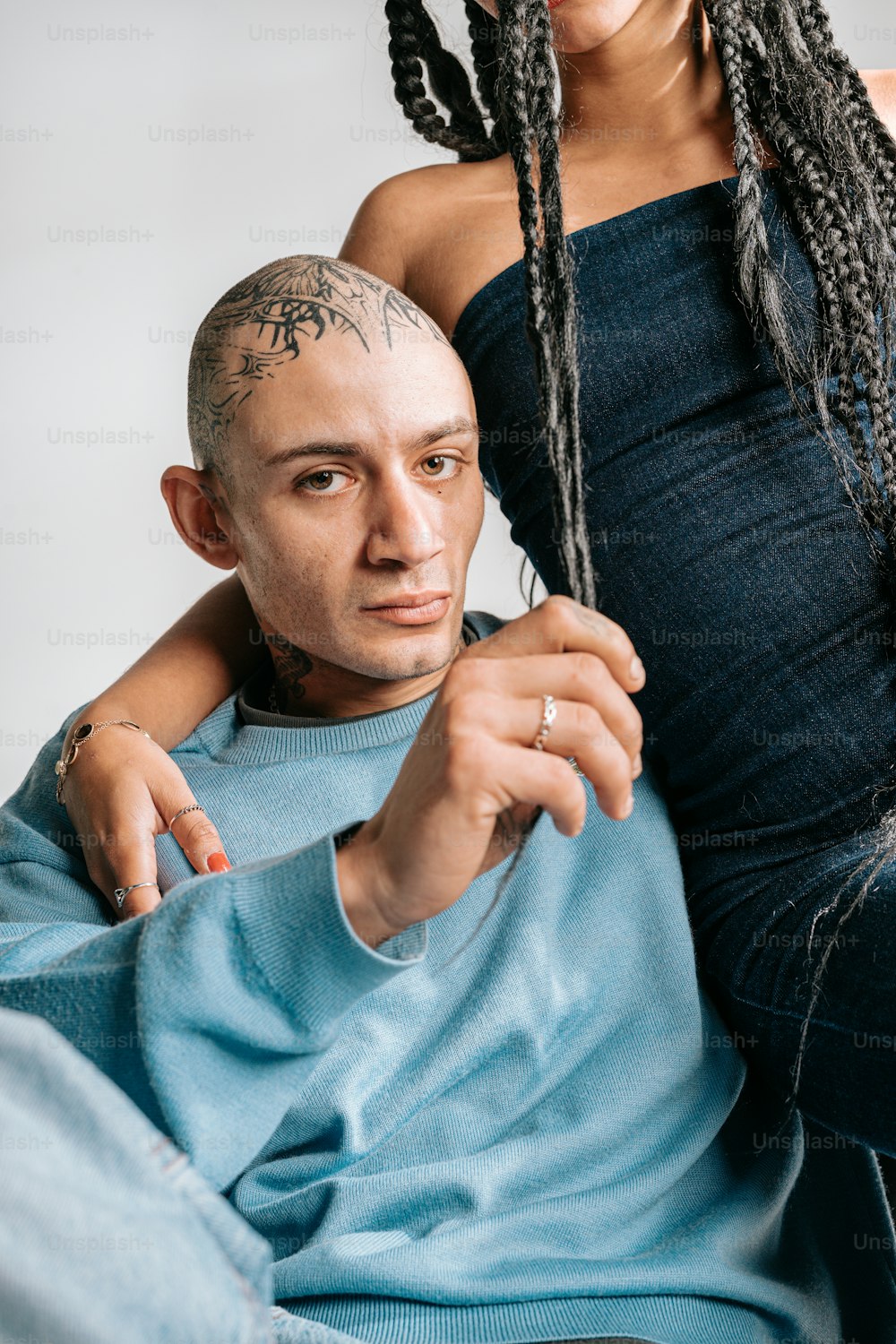 a man sitting next to a woman with dreadlocks