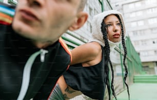 a woman with long braids standing next to a man