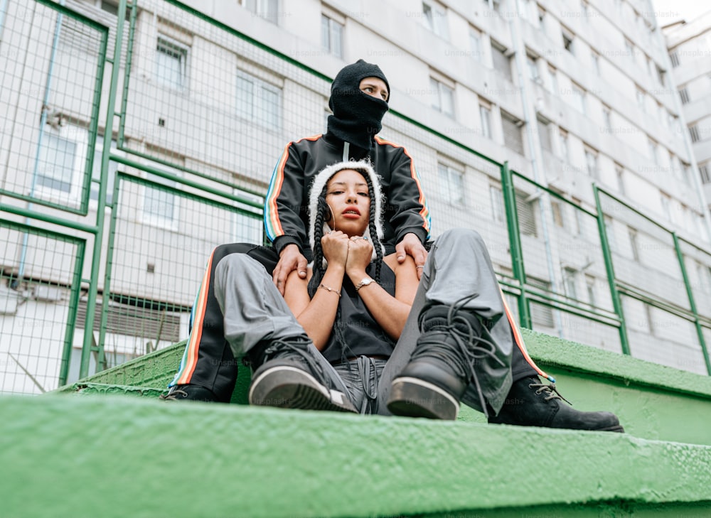 a man and a woman sitting on a green bench