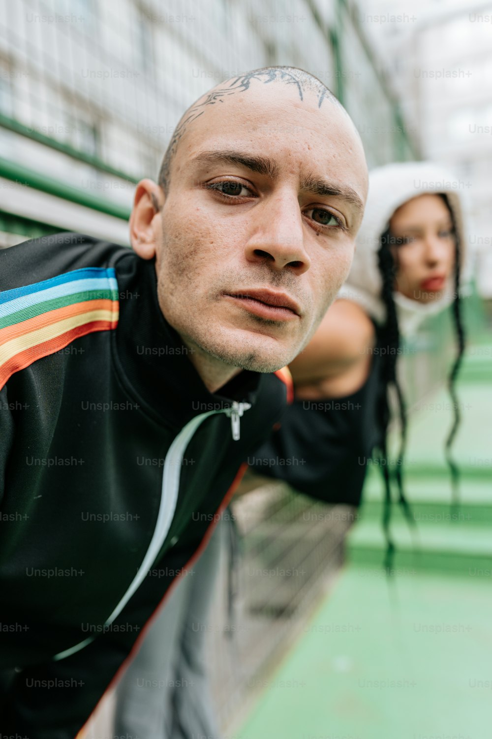 a man with a shaved head standing next to a woman