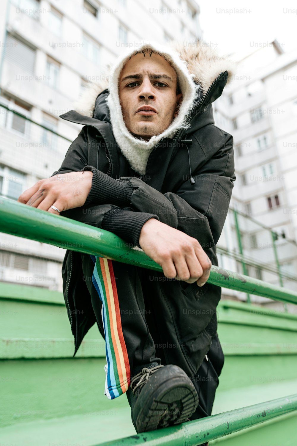 a man leaning on a rail in front of a building