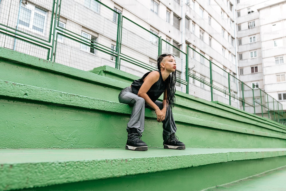 a woman sitting on a green set of stairs
