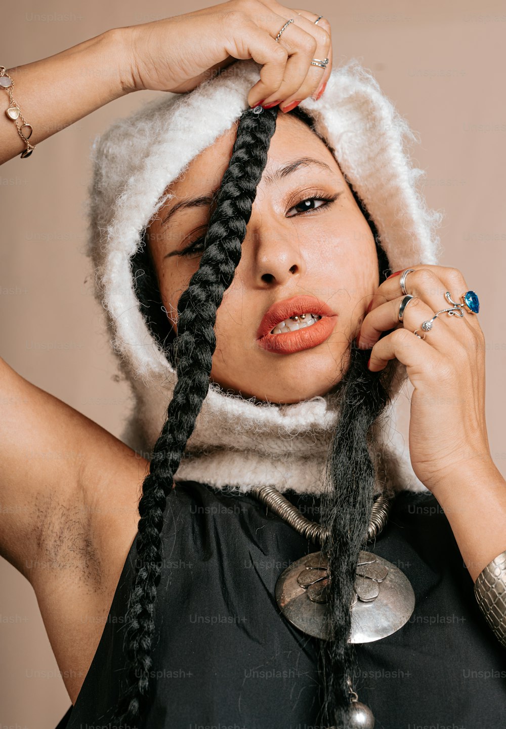 a woman with braids on her head and a hood