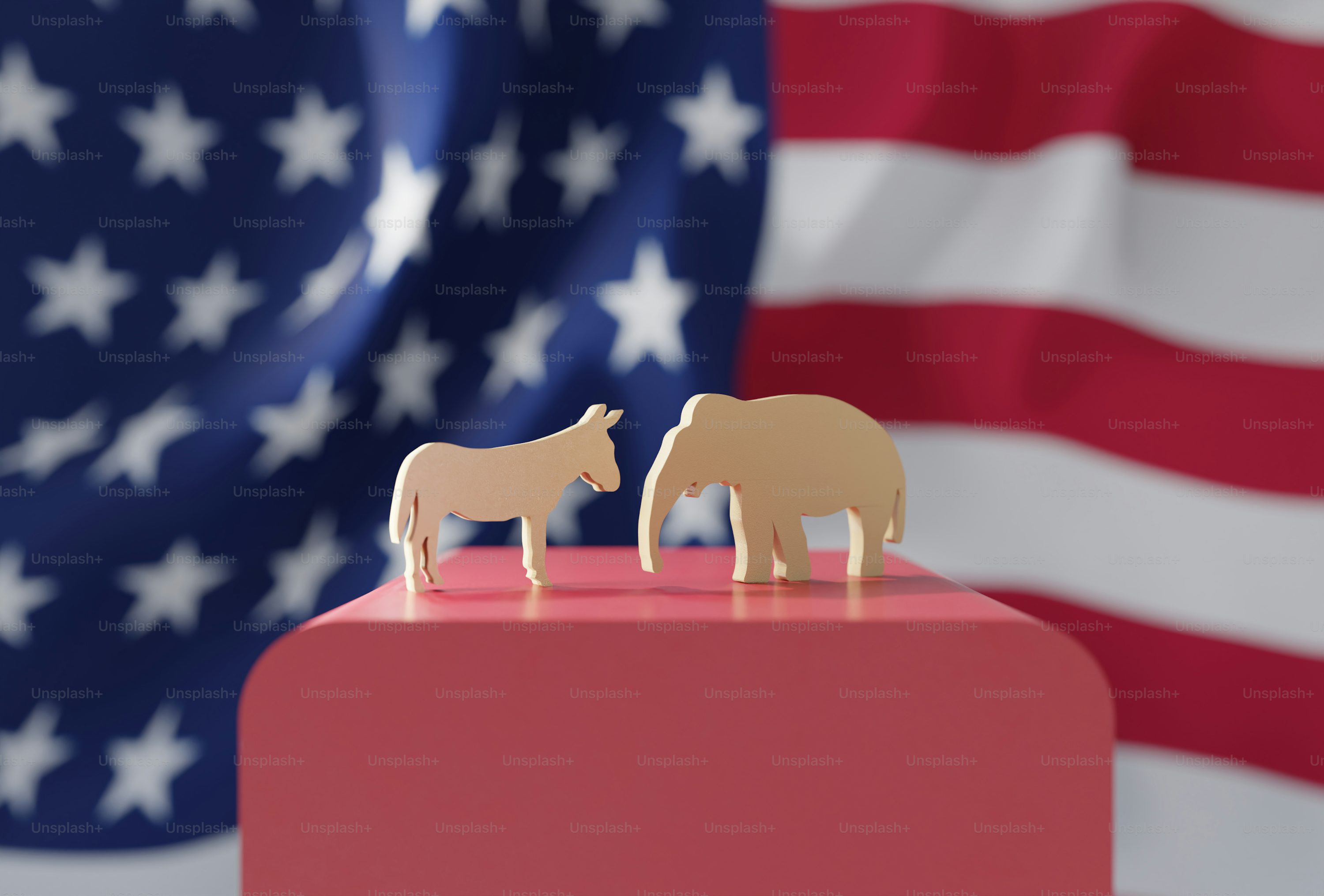 a couple of wooden animals standing on top of a red block