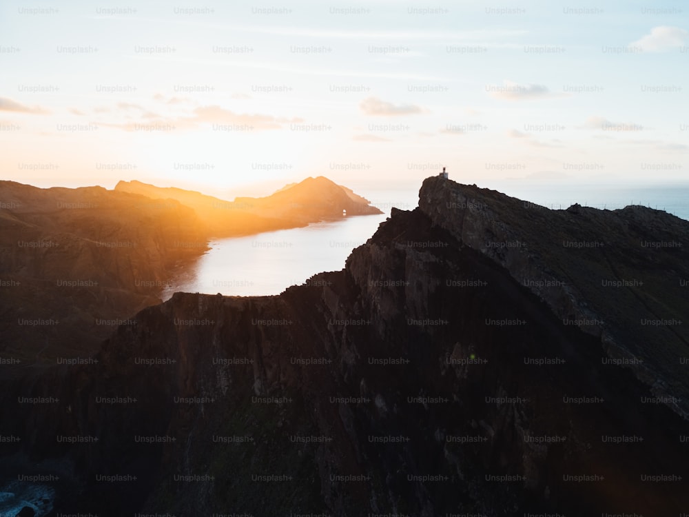 a person standing on top of a mountain overlooking a body of water