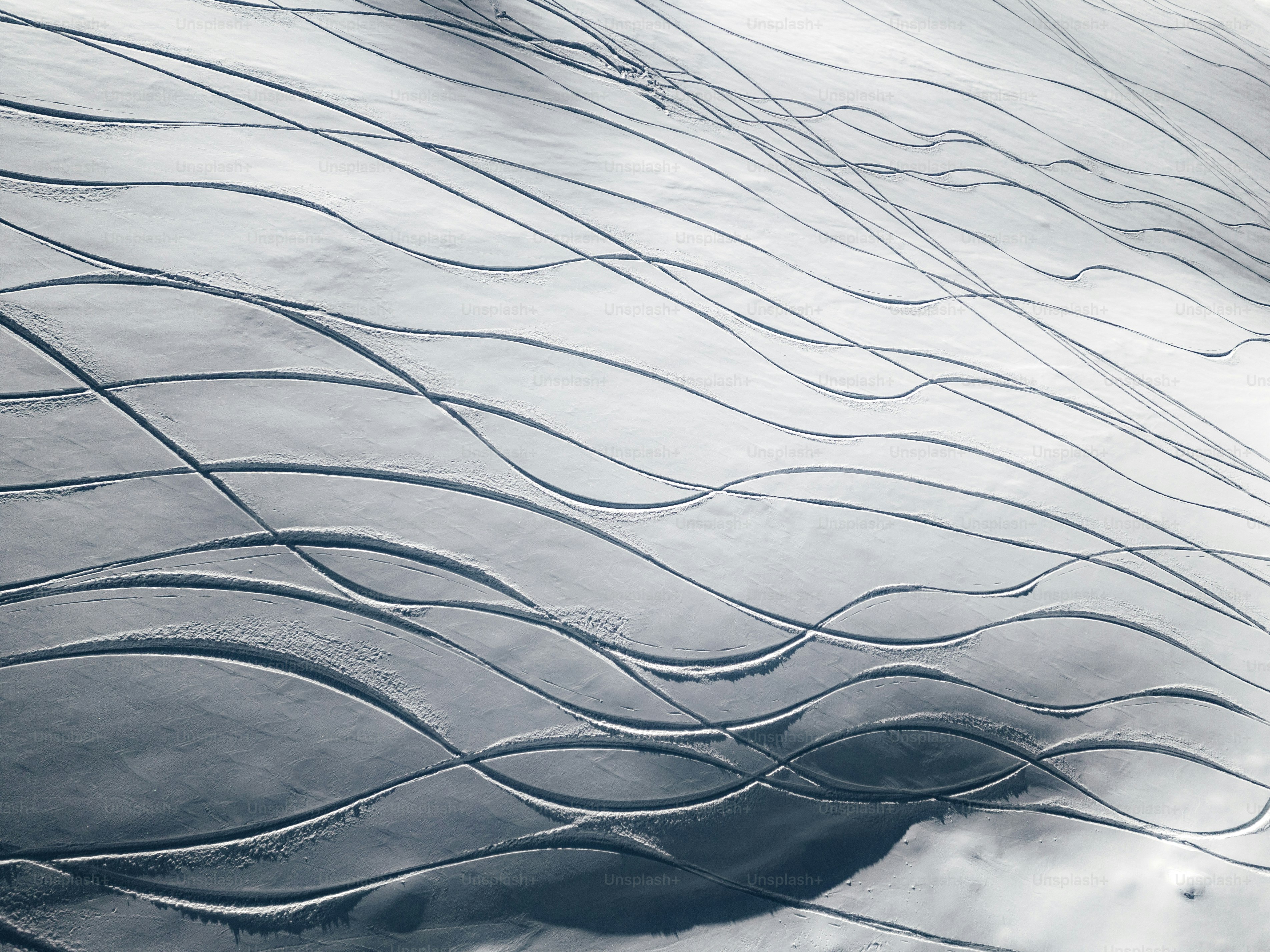 an airplane wing flying over a snow covered landscape