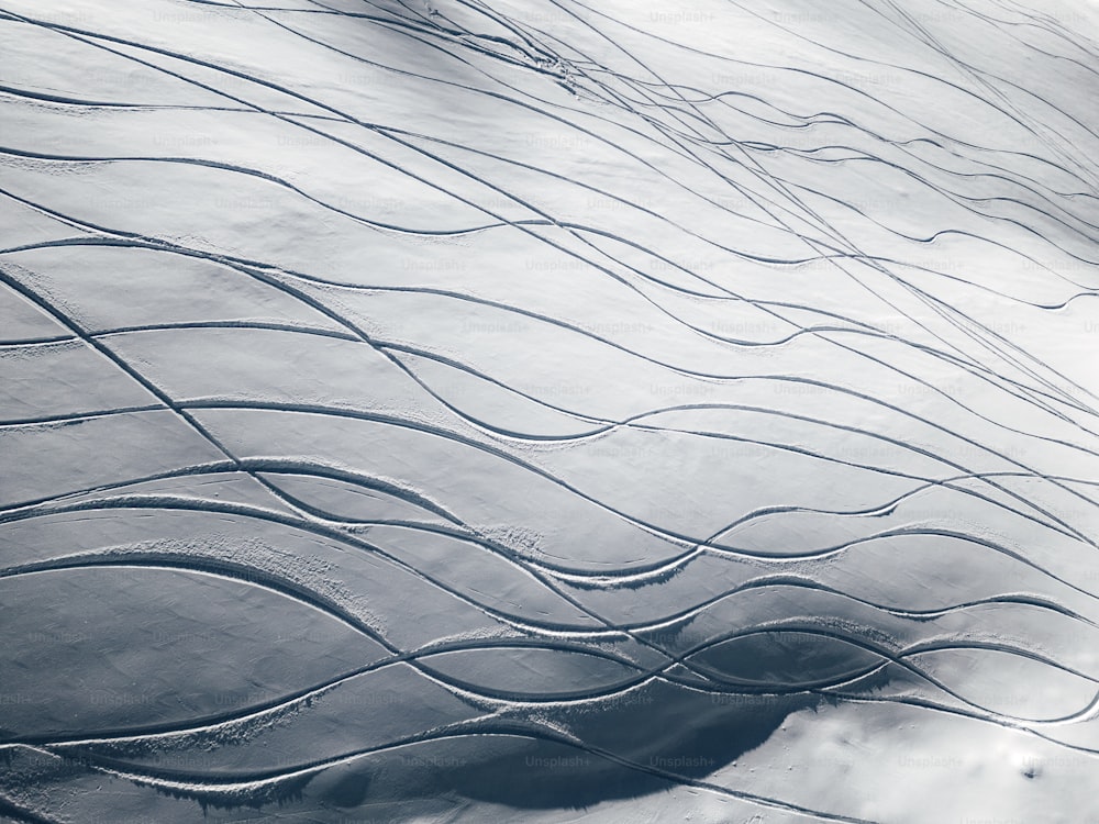 an airplane wing flying over a snow covered landscape