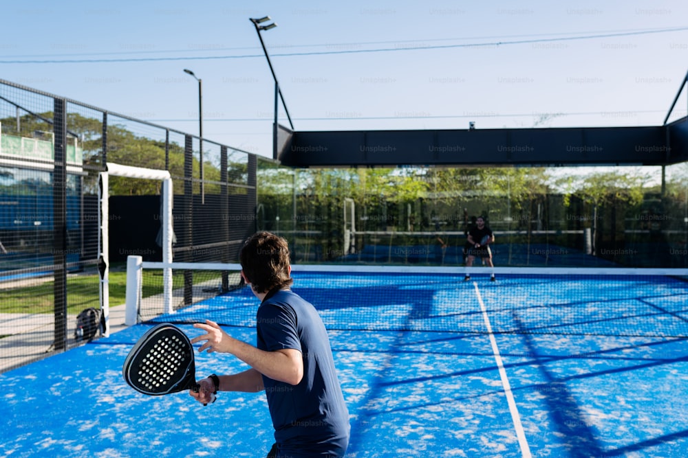 un homme tenant une raquette de tennis sur le dessus d’un court de tennis