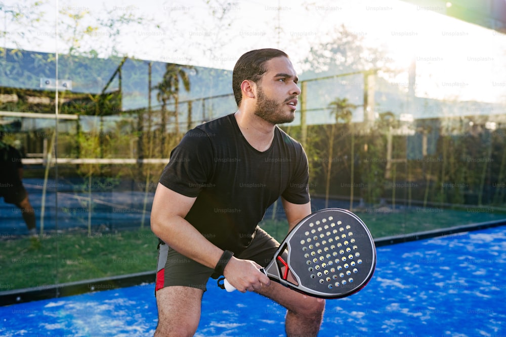 un homme tenant une raquette de tennis sur le dessus d’un court de tennis