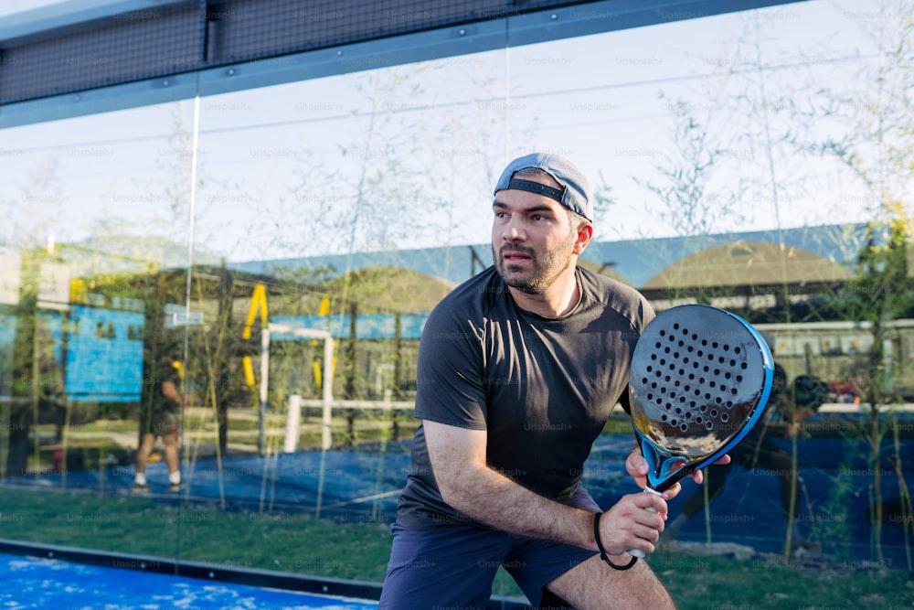 テニスコートの上でテニスラケットを持つ男性