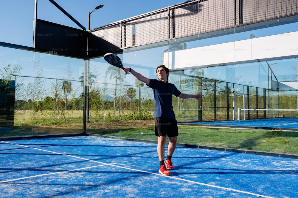 un homme debout sur un court de tennis tenant une raquette