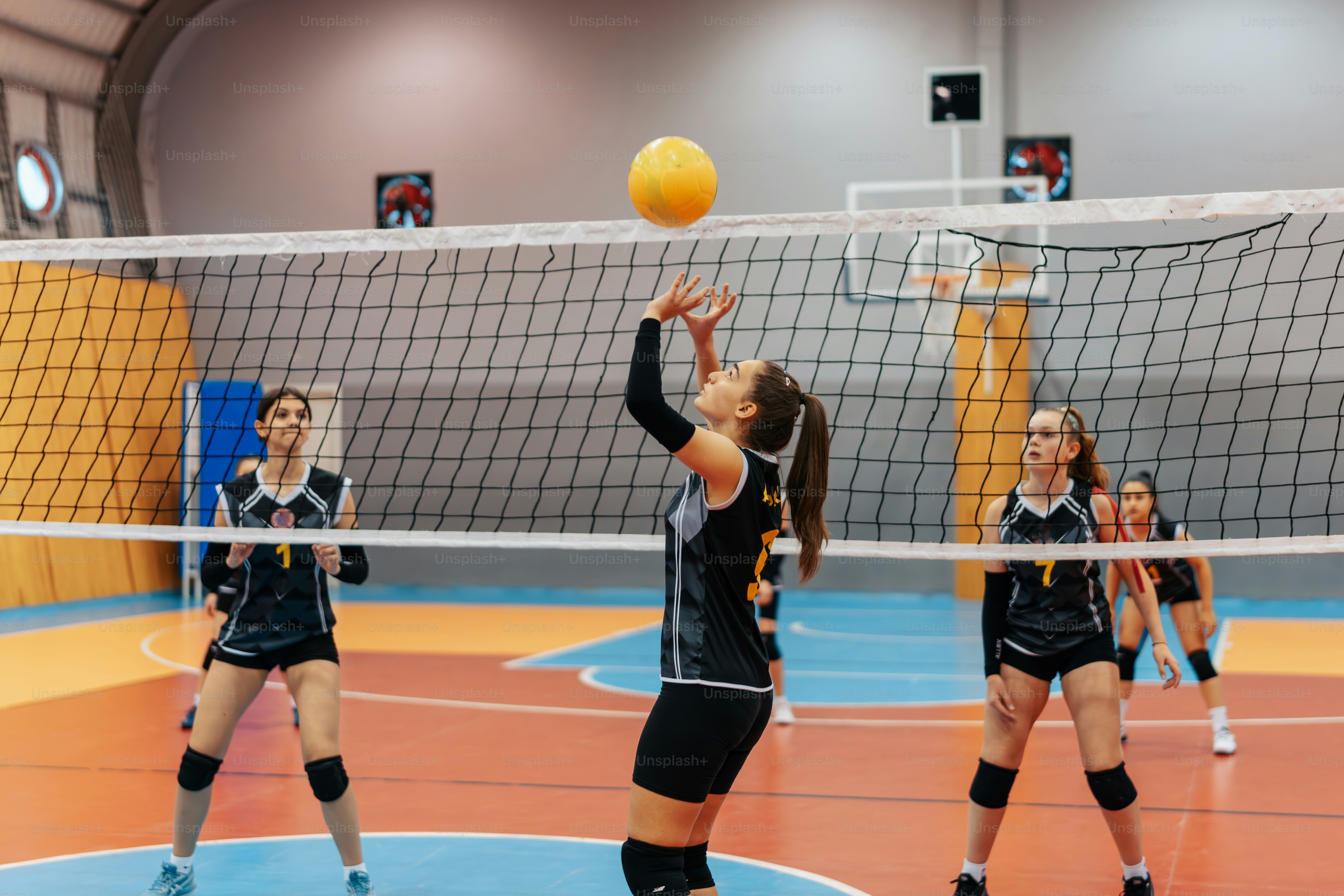 a group of young women playing a game of volleyball