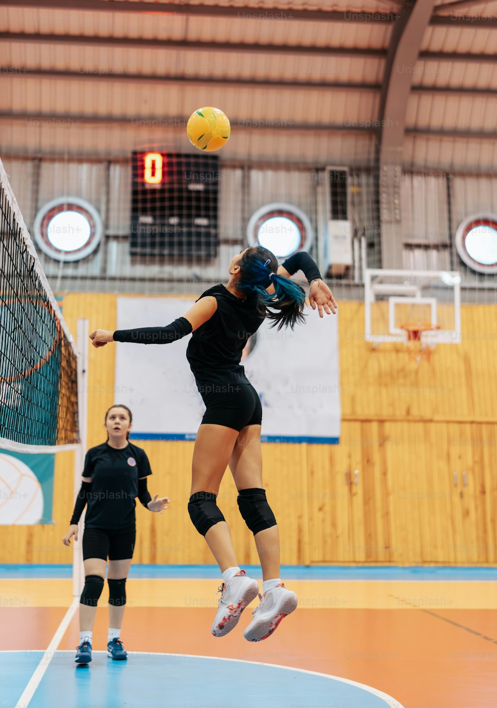 a woman jumping in the air to hit a volleyball